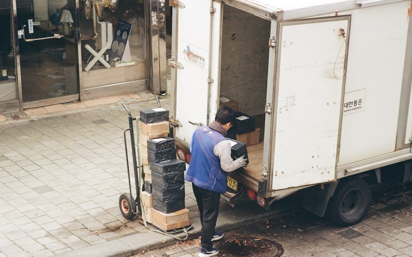 Man loading boxes from a truck onto a dolly.